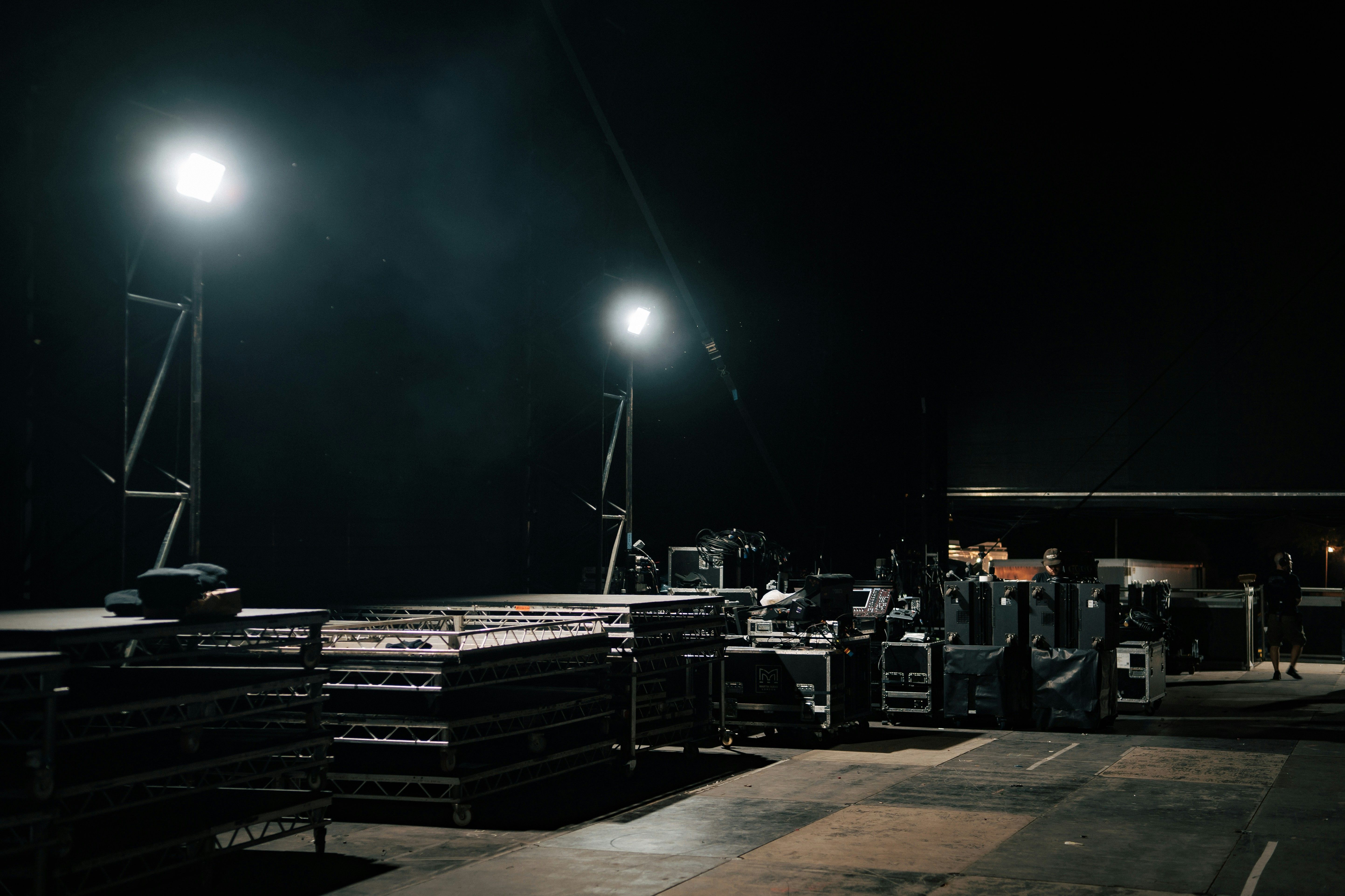 Stage decking, truss and flight cases at a night-time load-in