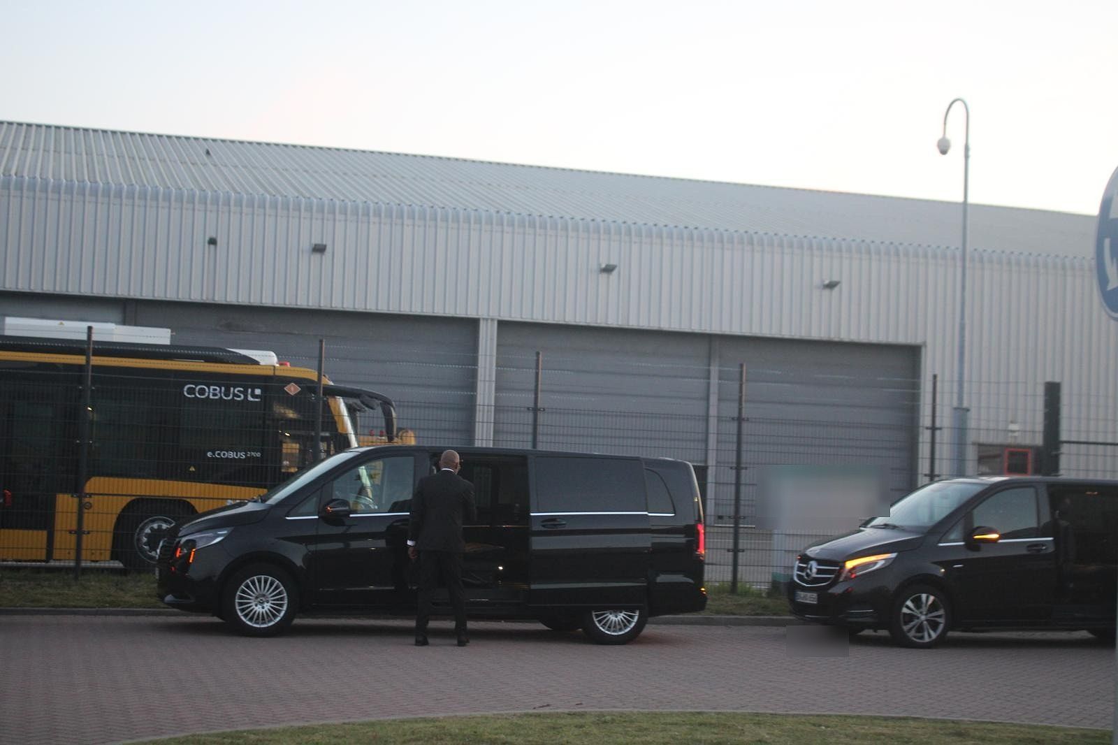 Chauffeurs waiting with the vans at dusk